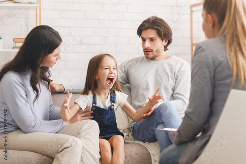 Shocked parents soothing their screaming little daughter at psychologist consultation