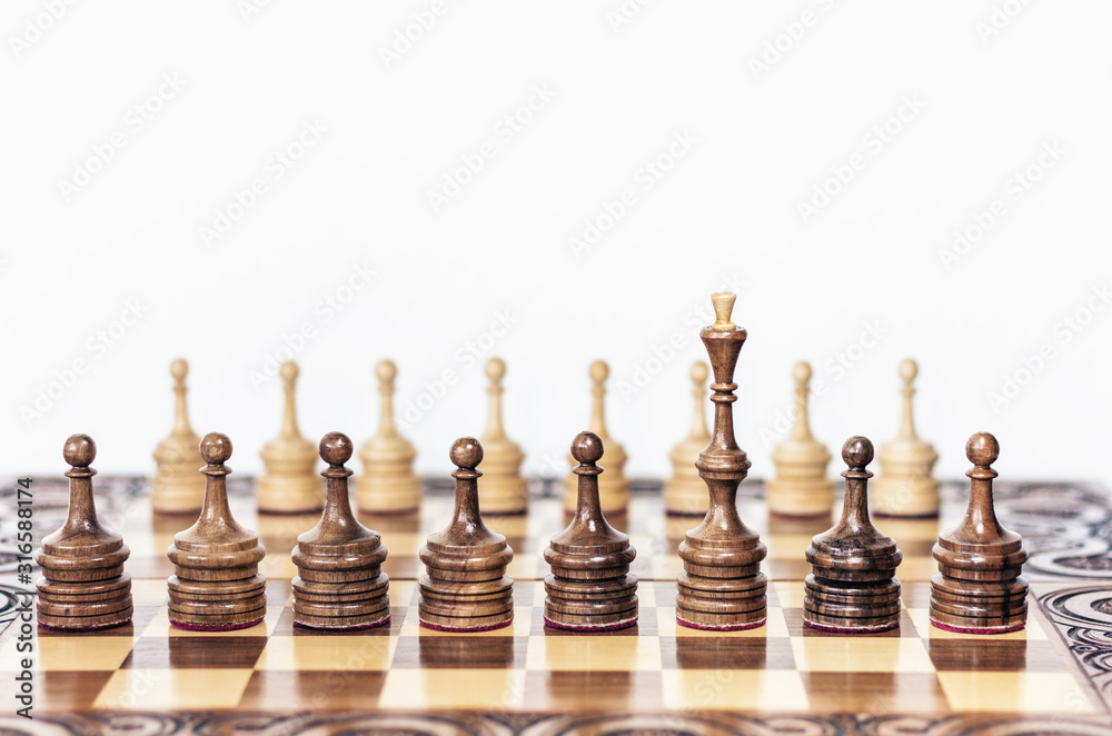 Wooden chess pieces on a chessboard, black queen and white pawns on the background, leadership retro concept. Wooden chess pieces on a chessboard, black queen and white pawns on the background, leadership retro concept.