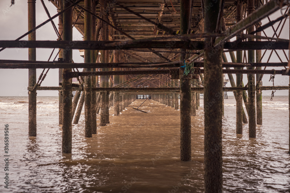 The rusty iron construction on the downside of a pier