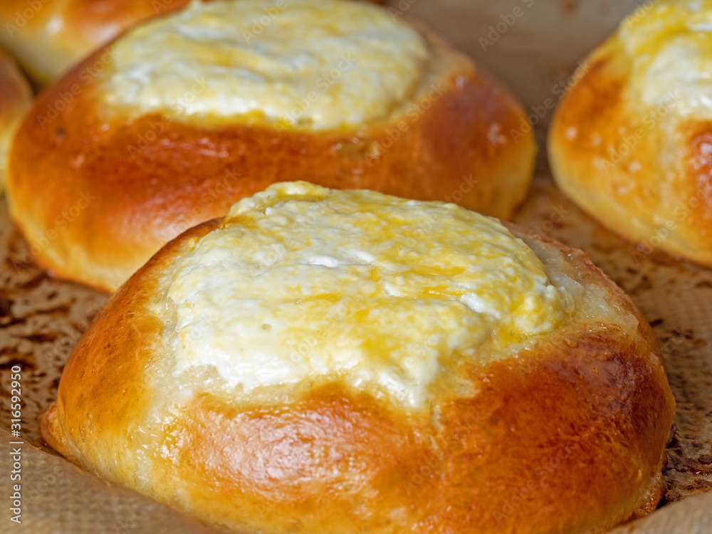 vatrushka, a round bun with cottage cheese filling. Traditional baking of Russian cuisine. Close-up, side view