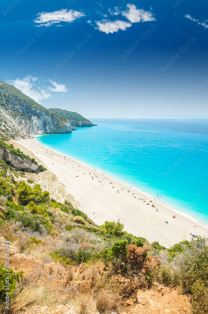 Milos beach on Lefkada island, Greece. Mylos beach near the Agios Nikitas village on Lefkada, Greece. People relaxing at the beach