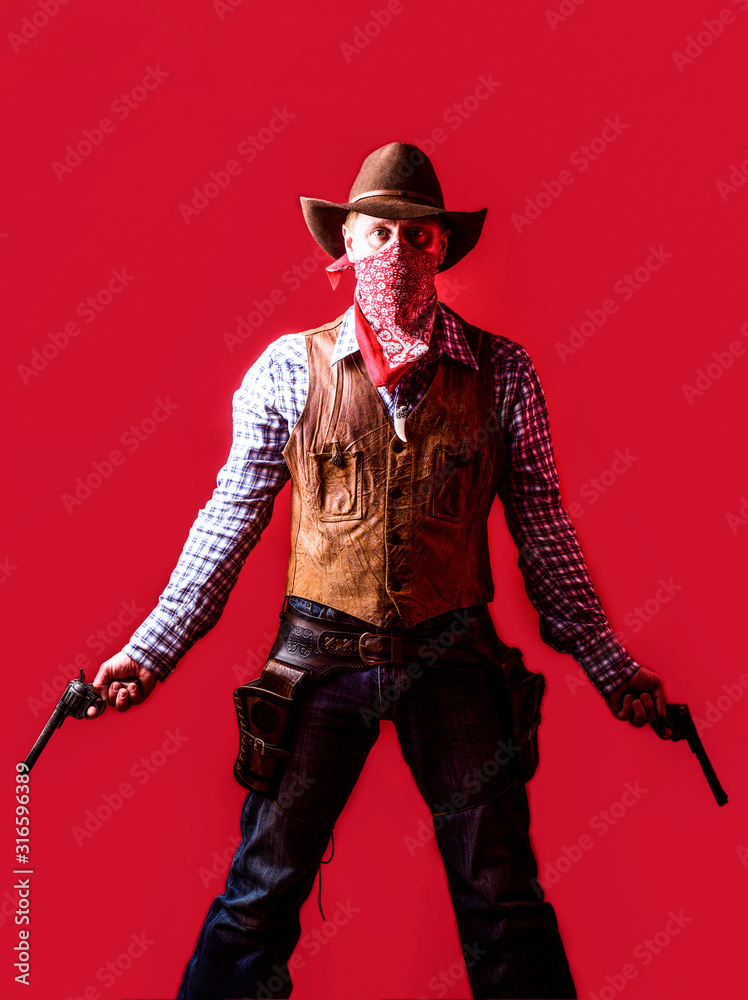 American bandit in mask, western man with hat. Man wearing cowboy hat, gun. West, guns. Portrait of a cowboy. owboy with weapon on red background American bandit in mask, western man with hat. Man wearing cowboy hat, gun. West, guns. Portrait of a cowboy. owboy with weapon on red background