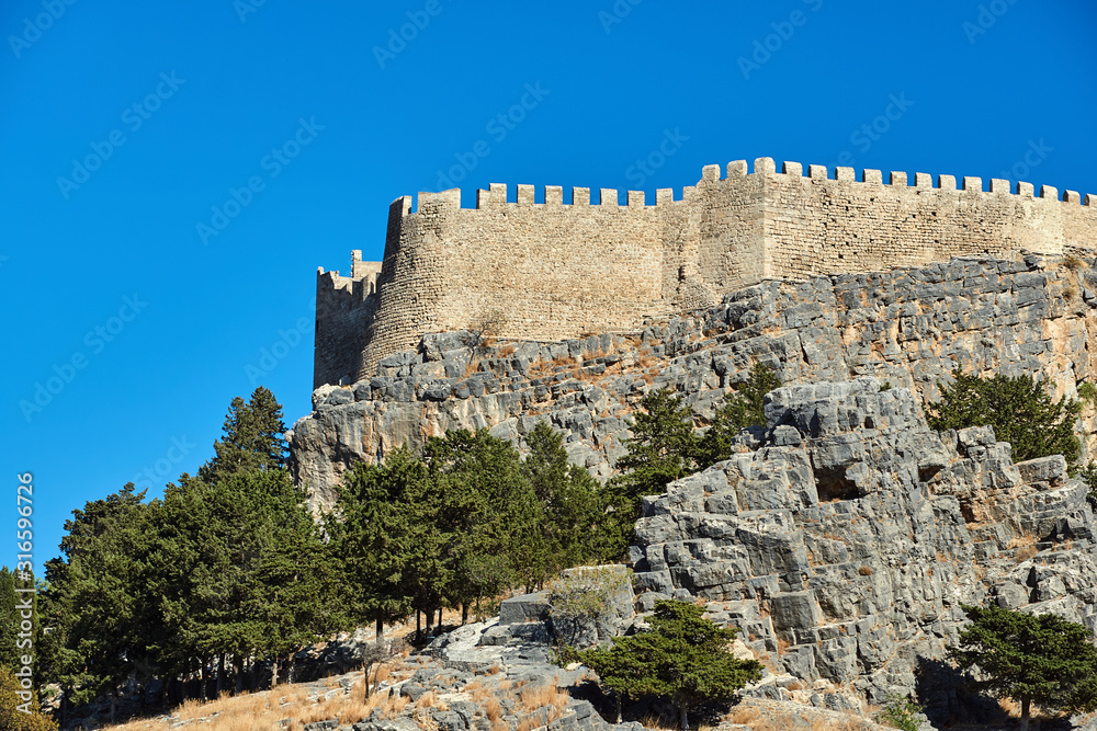 Medieval Walls of a fortress of the Joannite Order's on top of a rock in the city of Lindos.
