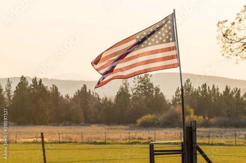 Sunset light passes through a waving U.S. flag near Terrebonne