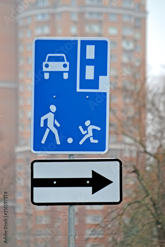 Playground area, living zone near the street as blue sign with people silhouettes with ball, urban diversity