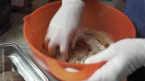 Footage of woman wearing white latex glove, knead sinced beef, making burgers
