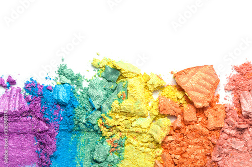 A broken rainbow colored eye shadow smear, make up palette isolated on a white background. Top view, flat lay. Holographic neon colors.