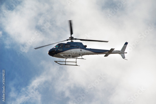 Fototapet helicopter in the sky with clouds