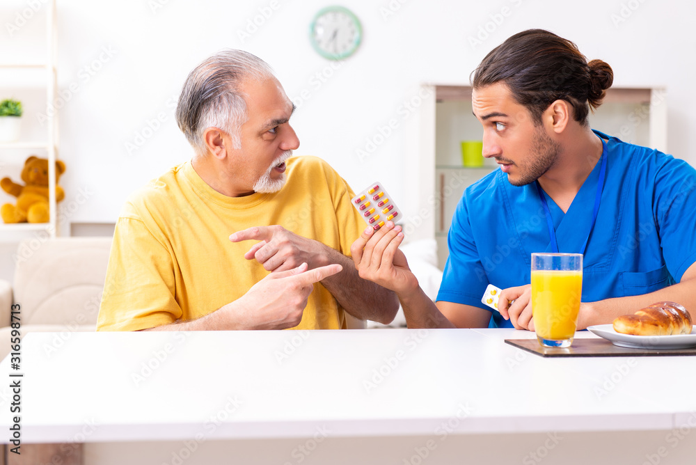 Young male doctor visiting old patient at home Young male doctor visiting old patient at home
