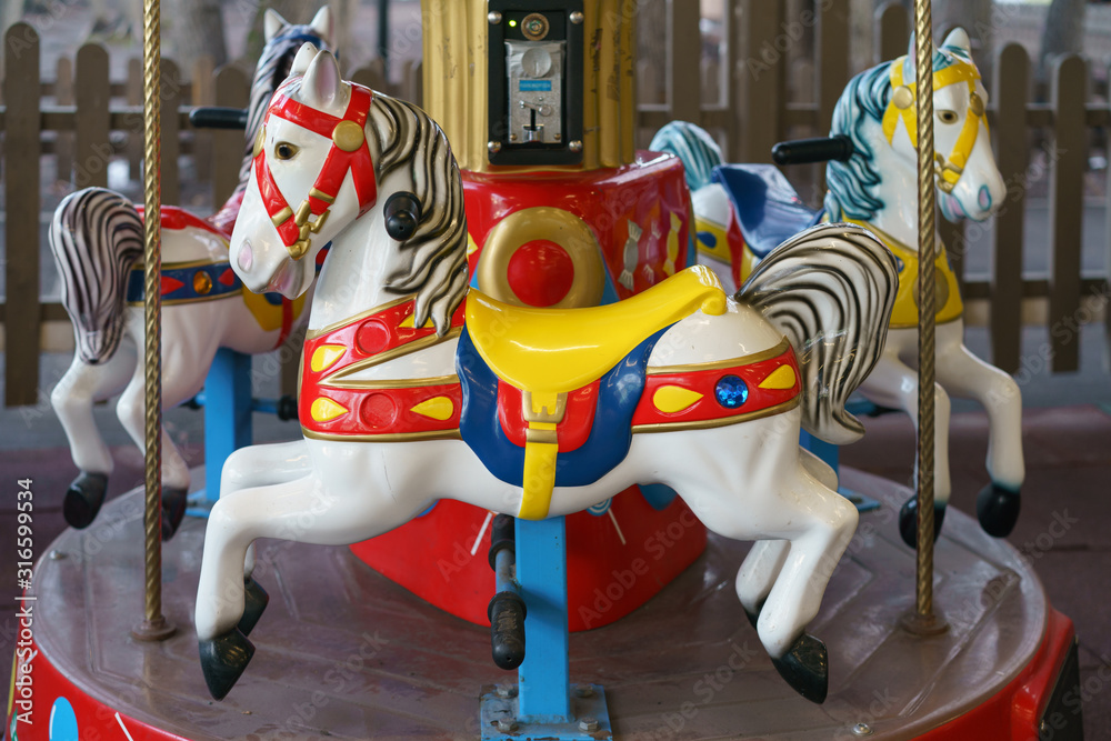 Riding around a horses carousel in winter day. Chrismas Eve and New Year mood. Amusement park for children. Concepts of holidays and festive mood.