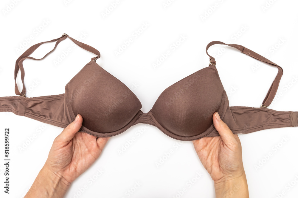Female woman hands holding brown spotted bra on white background Female woman hands holding brown spotted bra on white background