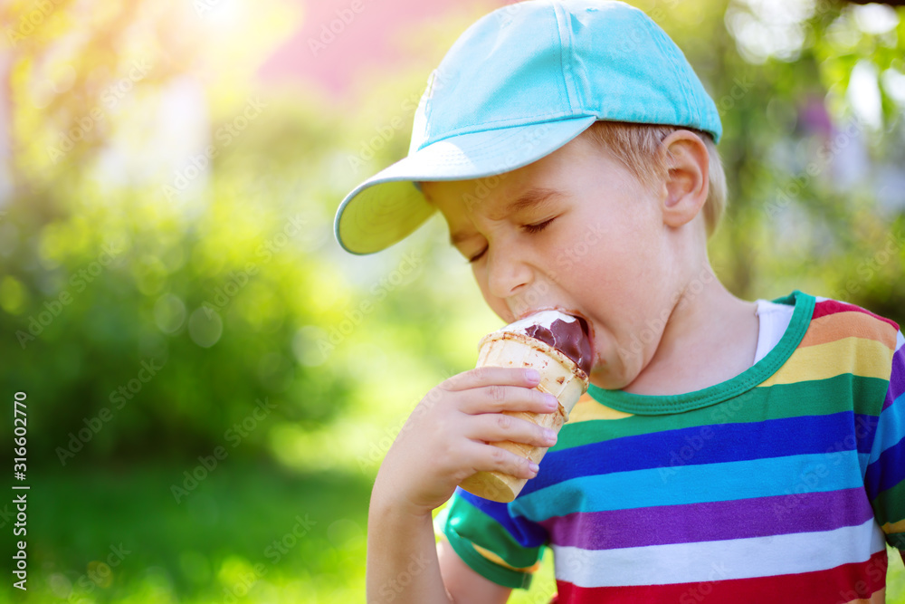 Happy child eating ice cream outdoors in summer Happy child eating ice cream outdoors in summer