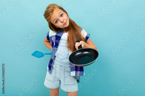 Teenager caucasian girl is going to fry something with a pan isolated on blue background