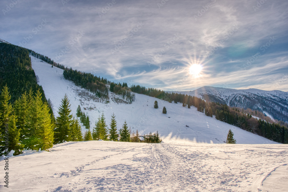 Sun over winter mountains, covered with snow