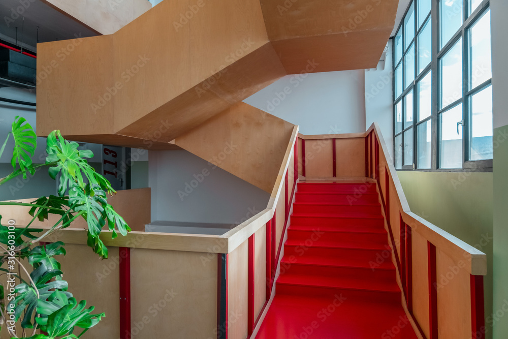 close up vibrant red staircase with monstera leaves in the interior close up vibrant red staircase with monstera leaves in the interior