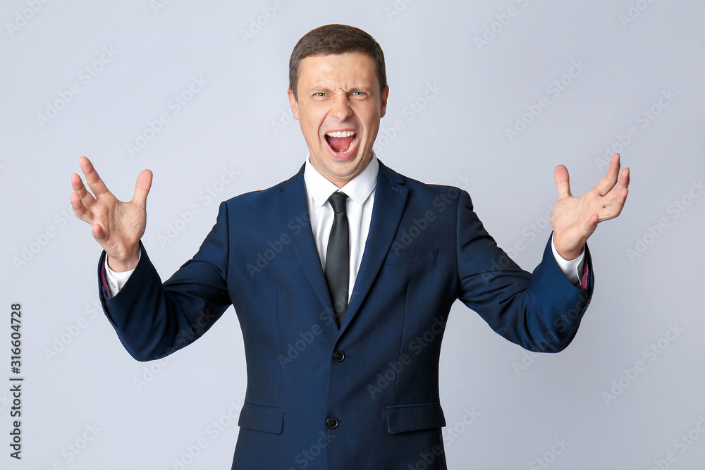 Portrait of angry businessman on grey background Portrait of angry businessman on grey background