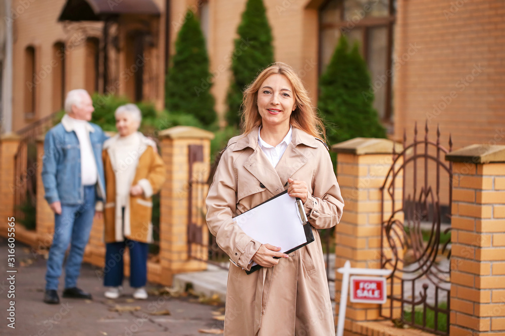 Obraz premium Female real estate agent near house for sale outdoors