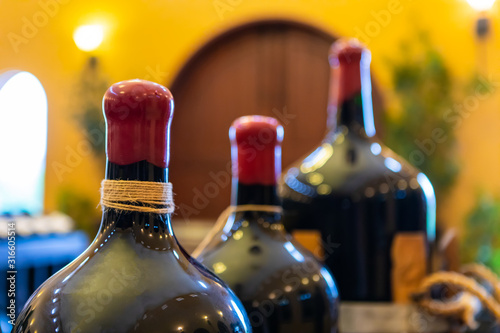 set of red wax-sealed wine glass big size magnum bottles top selective focus close up, wines winery tasting room interior decor background photo