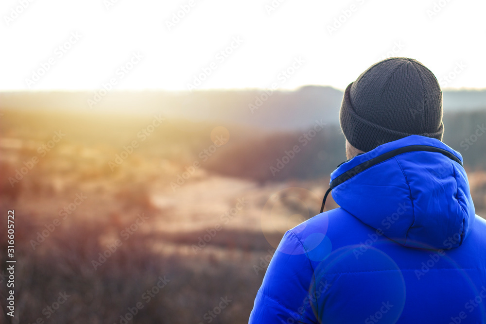 one guy looks into the distance in the steppe at sunset one guy looks into the distance in the steppe at sunset