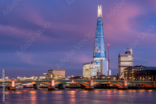 View of London city skyline on colorful sunset, with Southwark bridge over Thames river and the Shard skyscraper in the middle of the frame