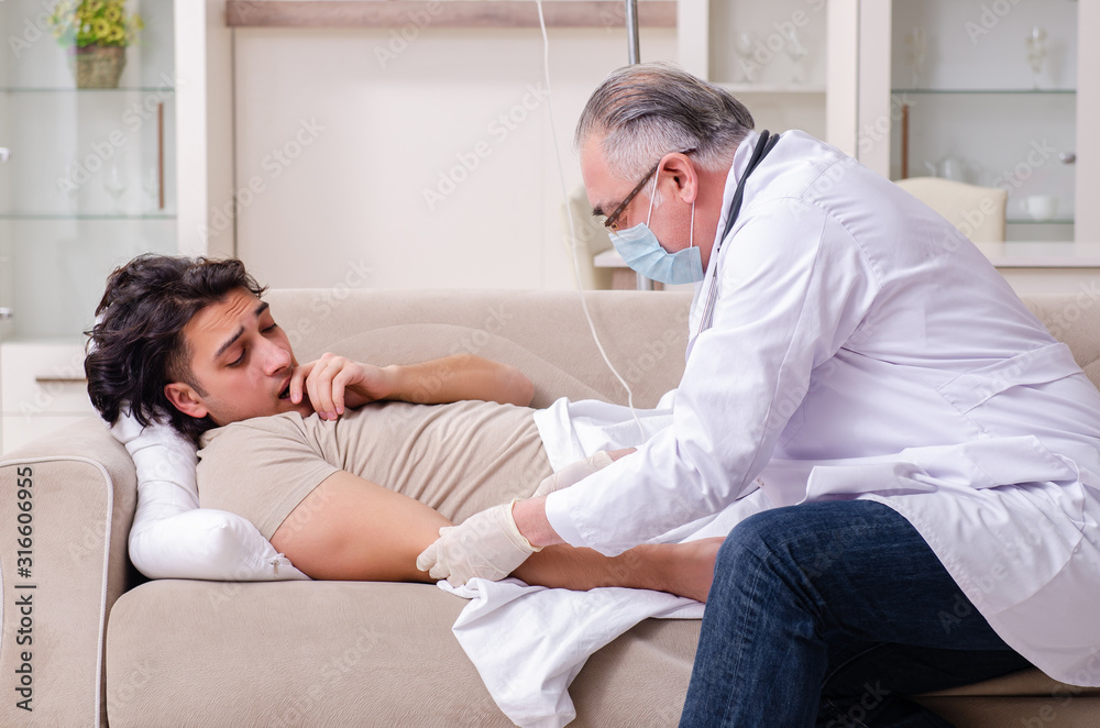 Fototapeta premium Old male doctor visiting young male patient