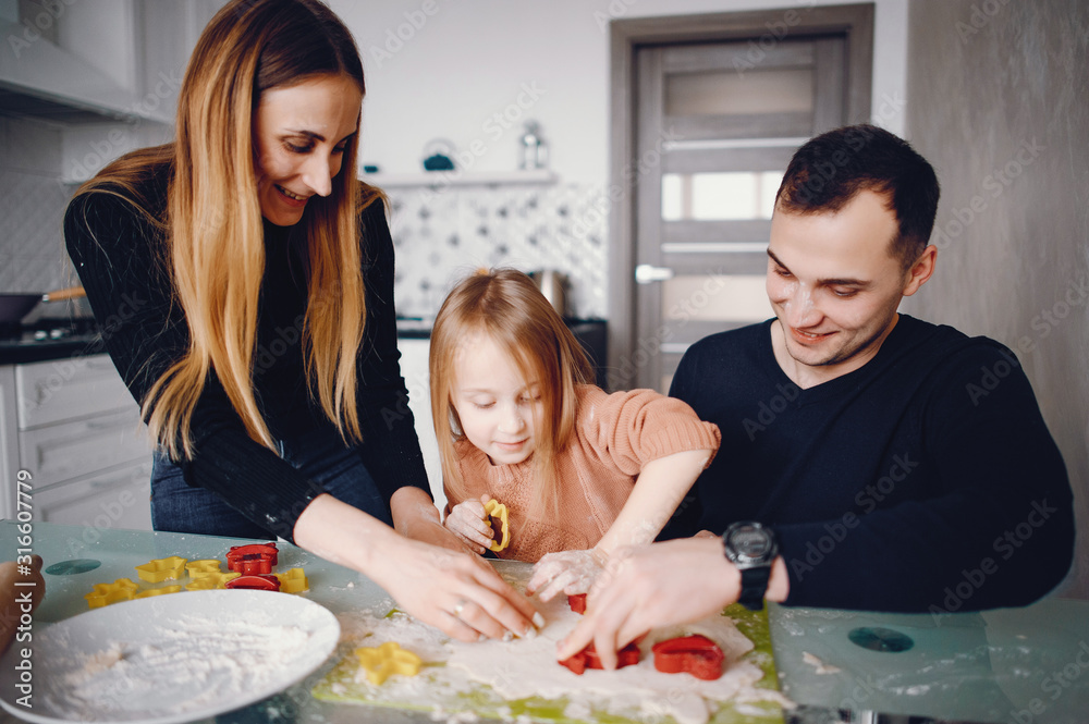 Family in a kitchen. Little girl with a dough. Family in a kitchen. Little girl with a dough.