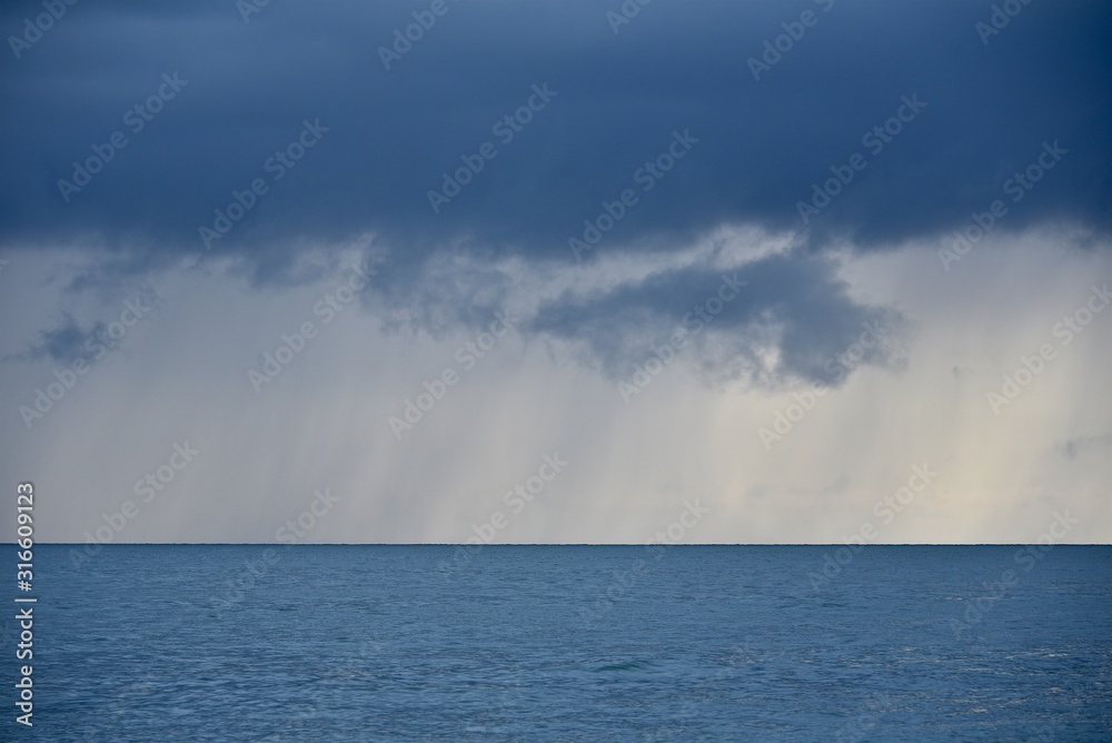 Rain over the sea. Sea landscape in blue tones.