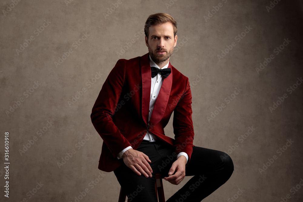 Bothered model looking forward while wearing tuxedo Bothered model looking forward while wearing tuxedo