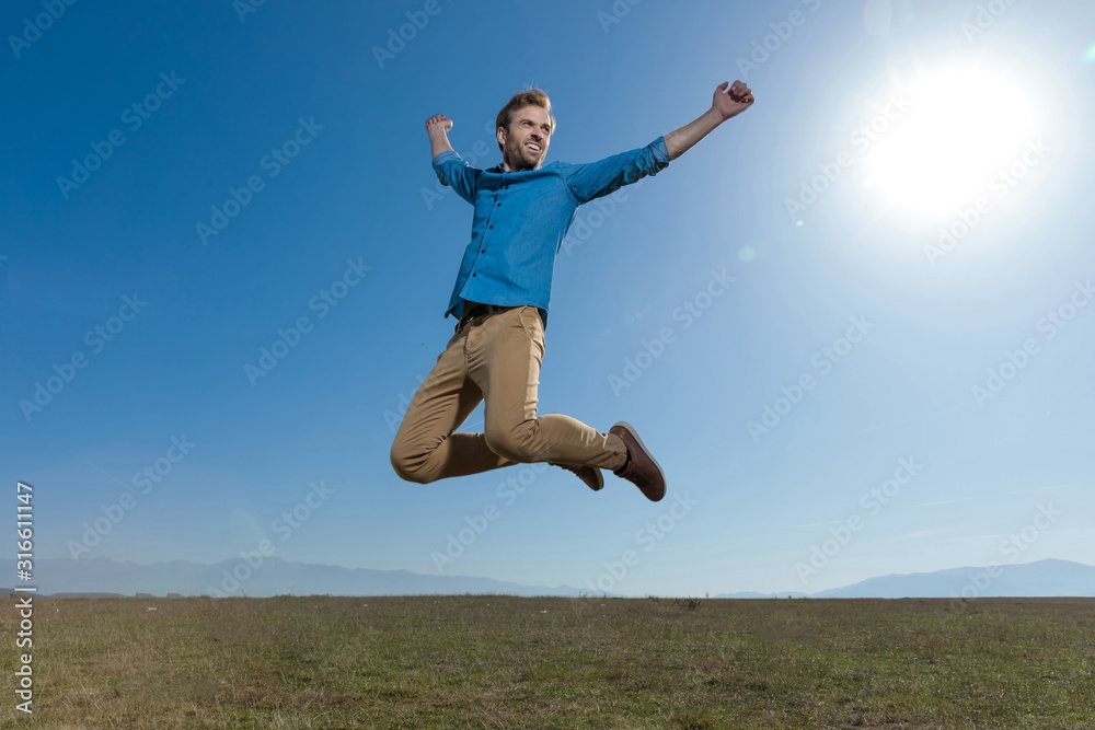 casual man jumping with hands in the air carefree casual man jumping with hands in the air carefree