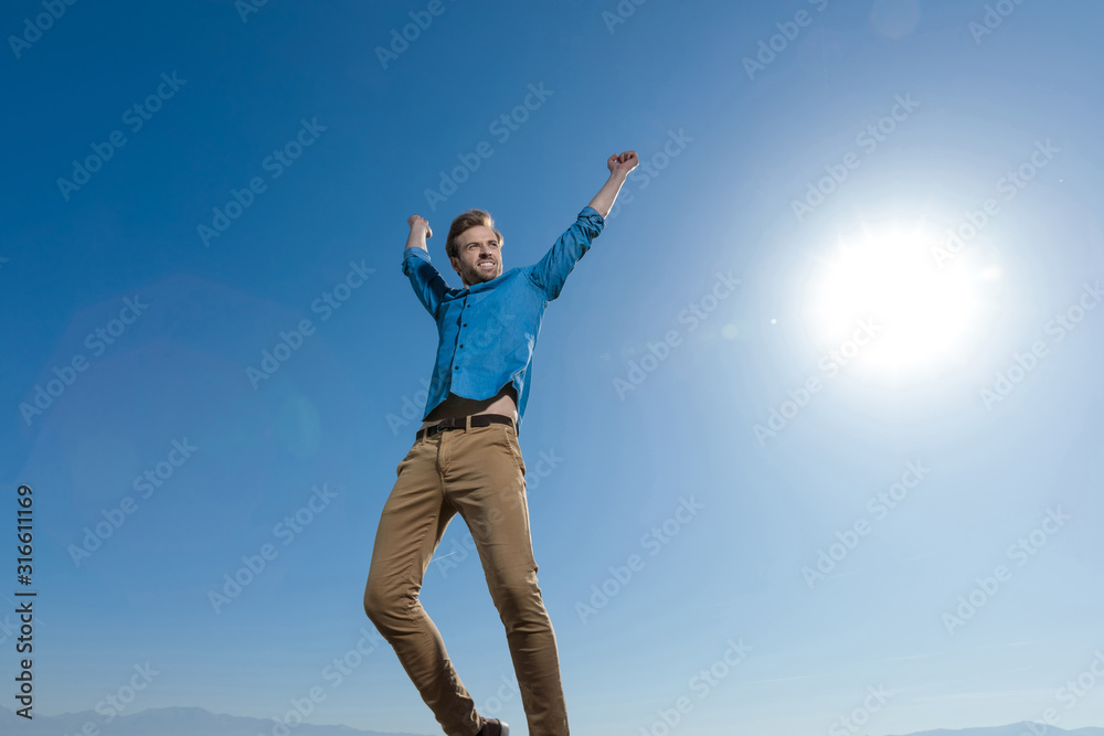 casual man wearing blue shirt jumping full of life