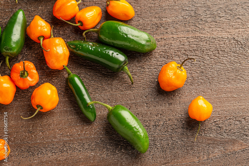 Fresh Picked Jalapeno and Habanero Peppers on wood background