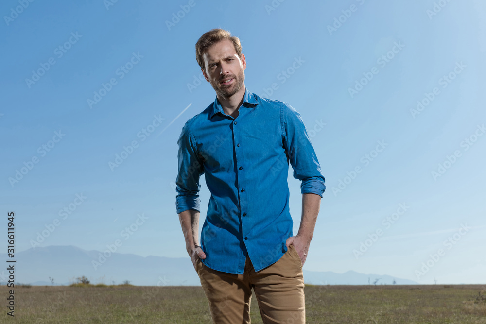 casual man standing with hands in pocket relaxed