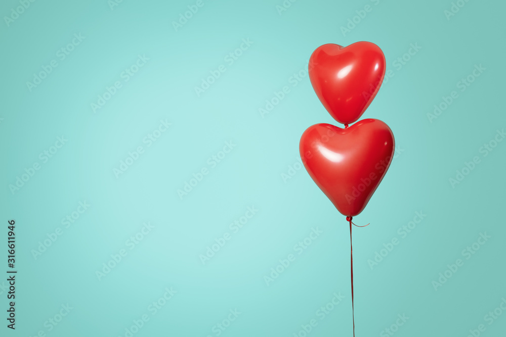 Two heart shaped red air baloon front of a font. Valentined day and romance concept.