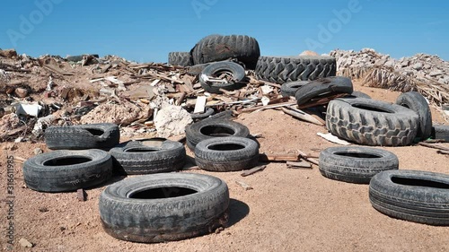 Tyres lies on the dump, abuse of environment. Big old black tyres and other garbage in desert near Sharm El Sheikh city in Egypt, environmental pollution photo