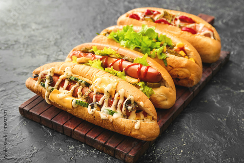 Tasty hot dogs on dark table