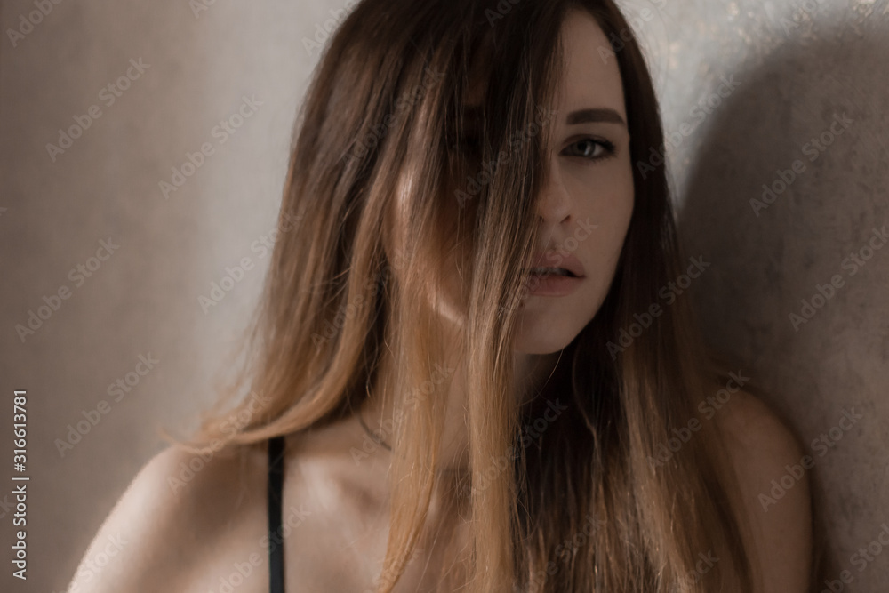 Portrait of a woman.Beautiful girl with bare shoulders, sexy look from under a lock of hair.Dramatic image, close-up Portrait of a woman.Beautiful girl with bare shoulders, sexy look from under a lock of hair.Dramatic image, close-up