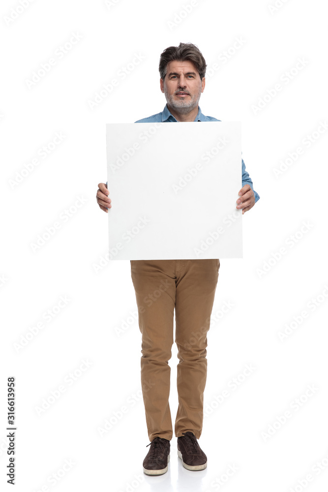 Serious casual man holding an empty billboard Serious casual man holding an empty billboard