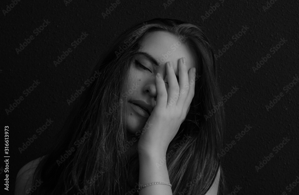 Dramatic black and white portrait of a beautiful lonely girl, isolated on a dark background in studio shot Dramatic black and white portrait of a beautiful lonely girl, isolated on a dark background in studio shot