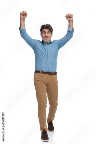 Happy casual man celebrating with both fists in the air