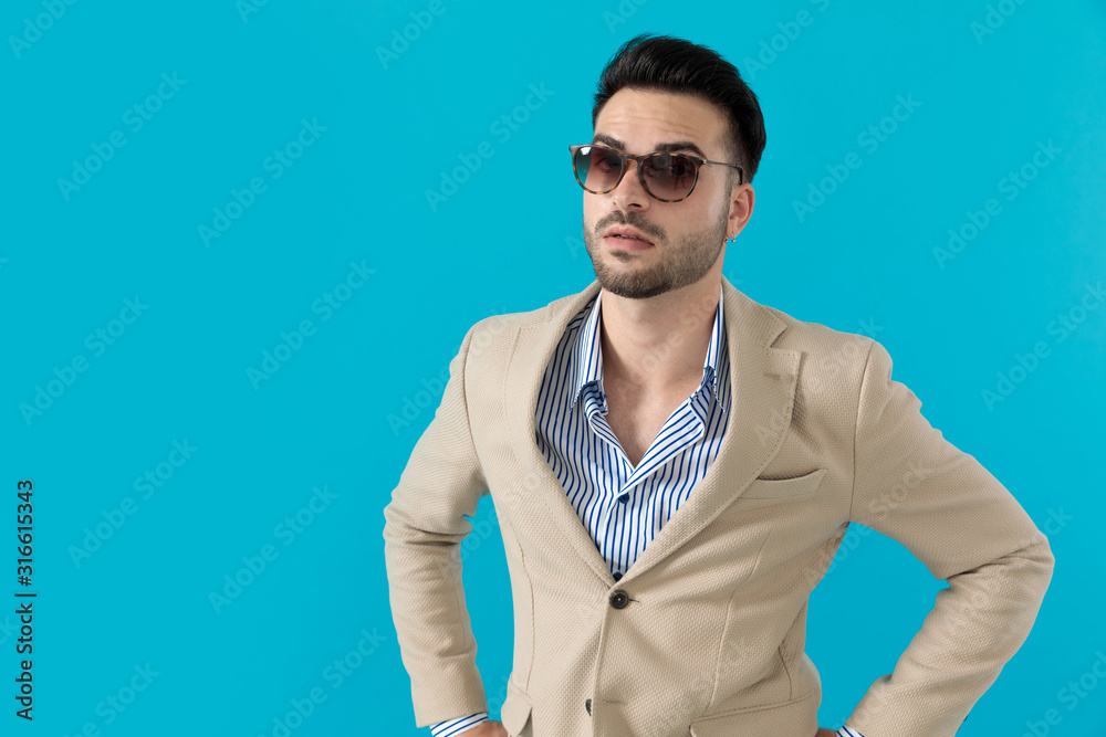 cool fashion model wearing sunglasses and waiting