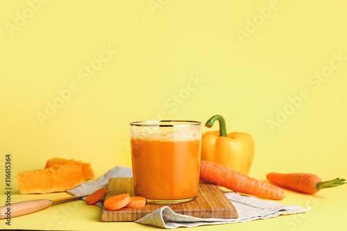 Glass of fresh vegetable juice on color background