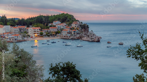 Picturesque morning view of Adriatic sea coast and Przno village with buildings on the rocks in Budva Riviera before sunrise. Montenegro.