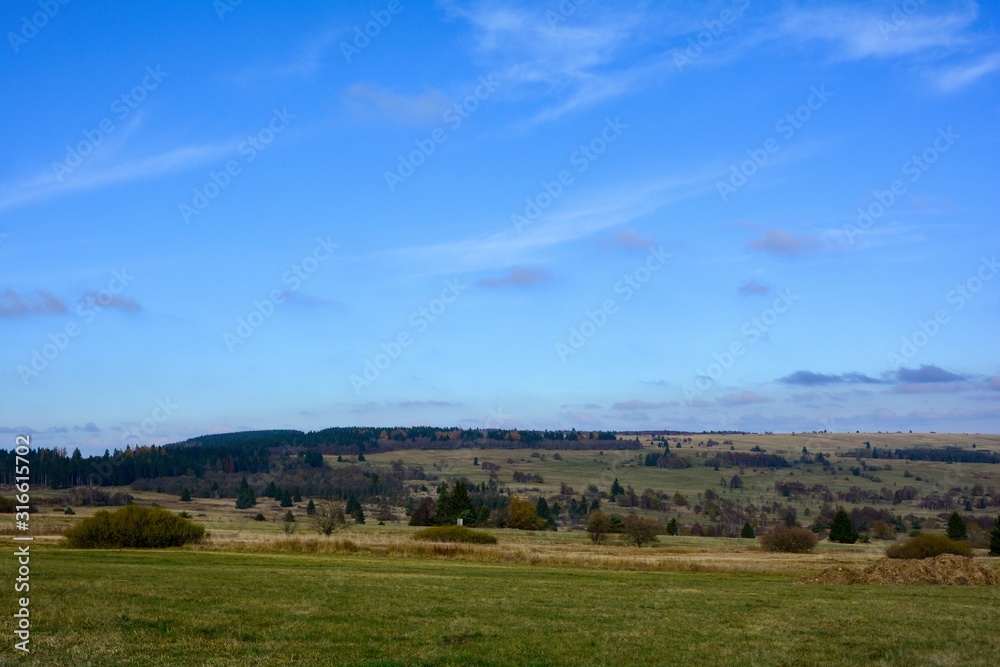 Green landscape  with big meadow, trees and blue sky in the Rhön, Bavaria, Germany
