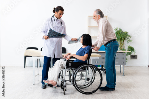 Old couple visiting young male doctor