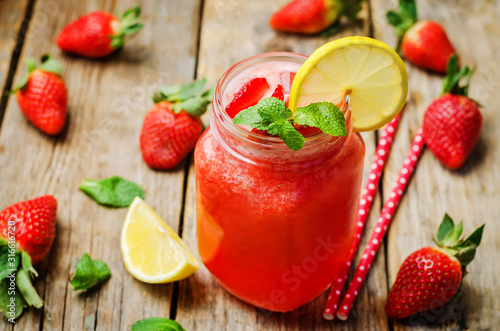 strawberry lemonade with fresh strawberries on a wood background