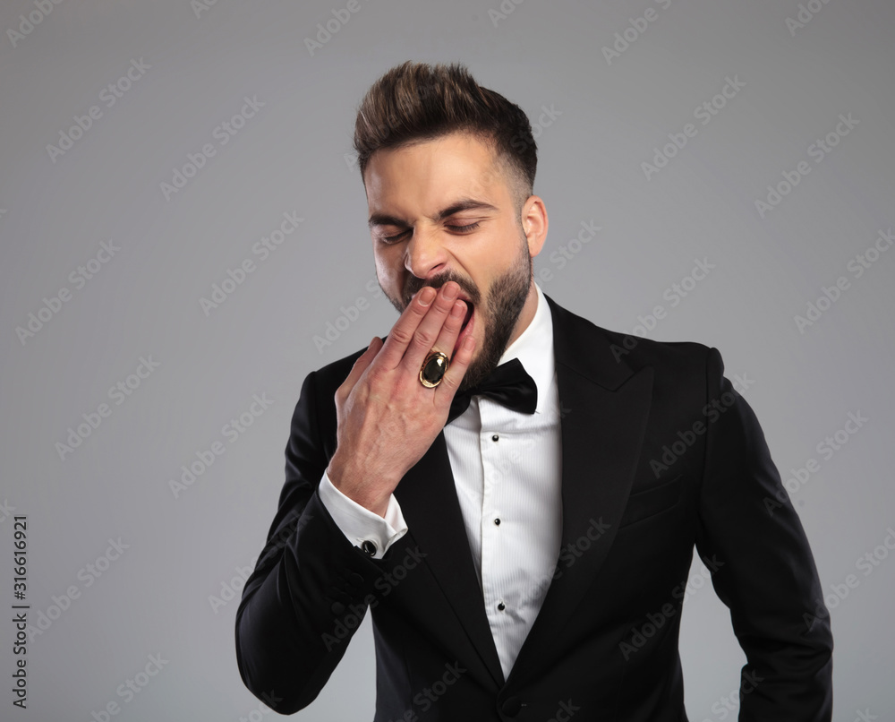 Elegant groom yawning and covering his mouth Elegant groom yawning and covering his mouth