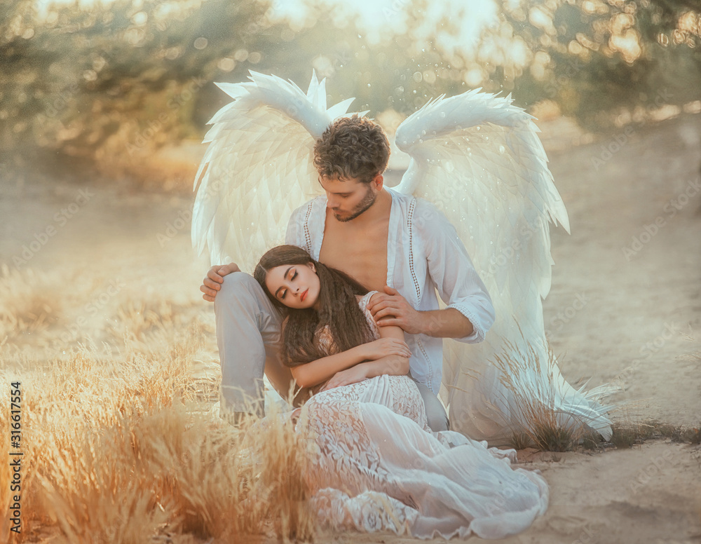 Men guardian angel protects and hugs young woman. Sleeping beauty vintage  pastel color, miracle dream. Fabulous old warm yellow autumn nature. Bright  sun shine light. Creative white suit design wing Stock Photo