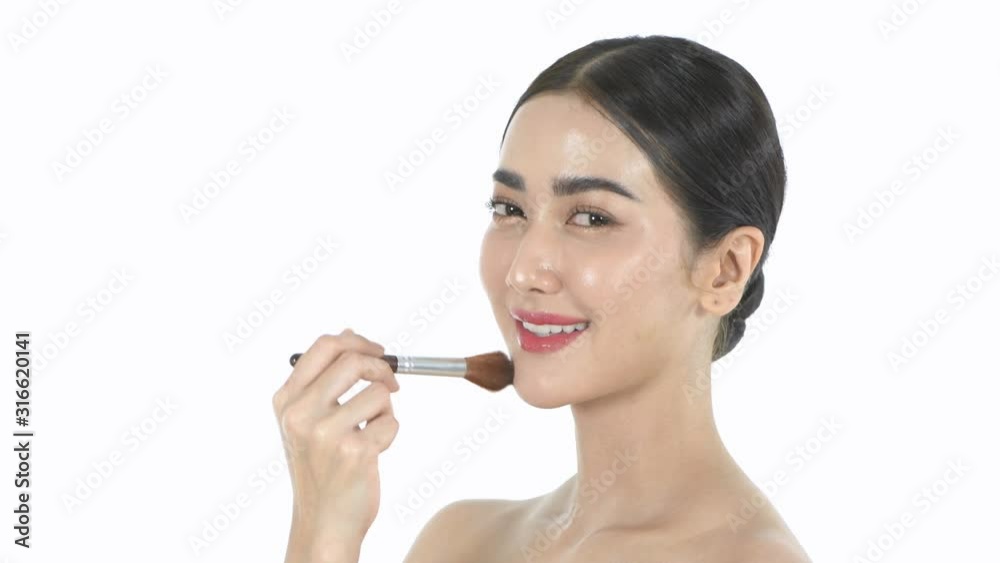 Beauty concept. A beautiful woman is using a brush to brush her face. 4k Resolution. Beauty concept. A beautiful woman is using a brush to brush her face. 4k Resolution.