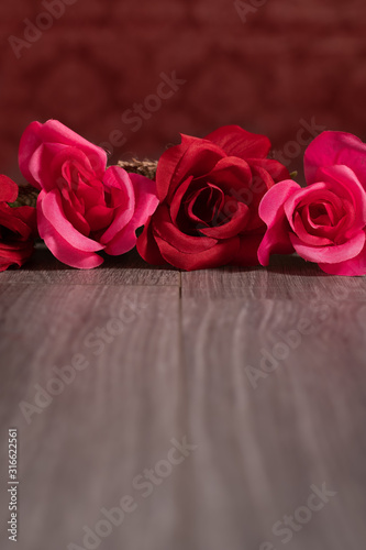 Red Silk Roses in a Row on Gray Wood Background