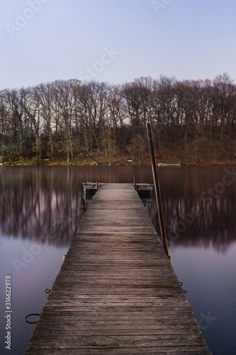 A dock on a calm pond in beautiful magenta night light